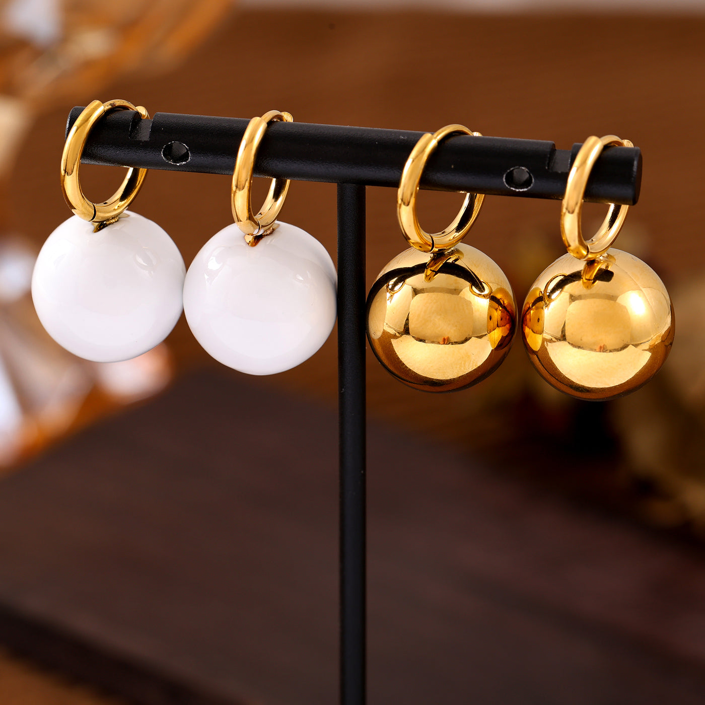 White and gold ball drop earrings with gold-tone hoop closures
