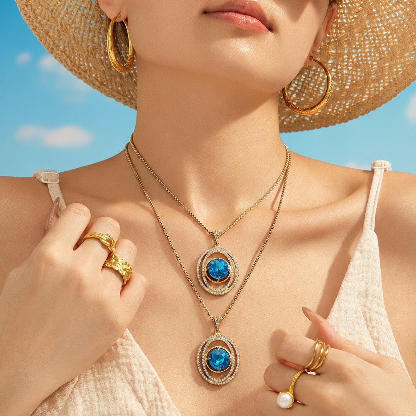 Model in a straw hat wearing layered blue glass pendant necklaces in an outdoor setting