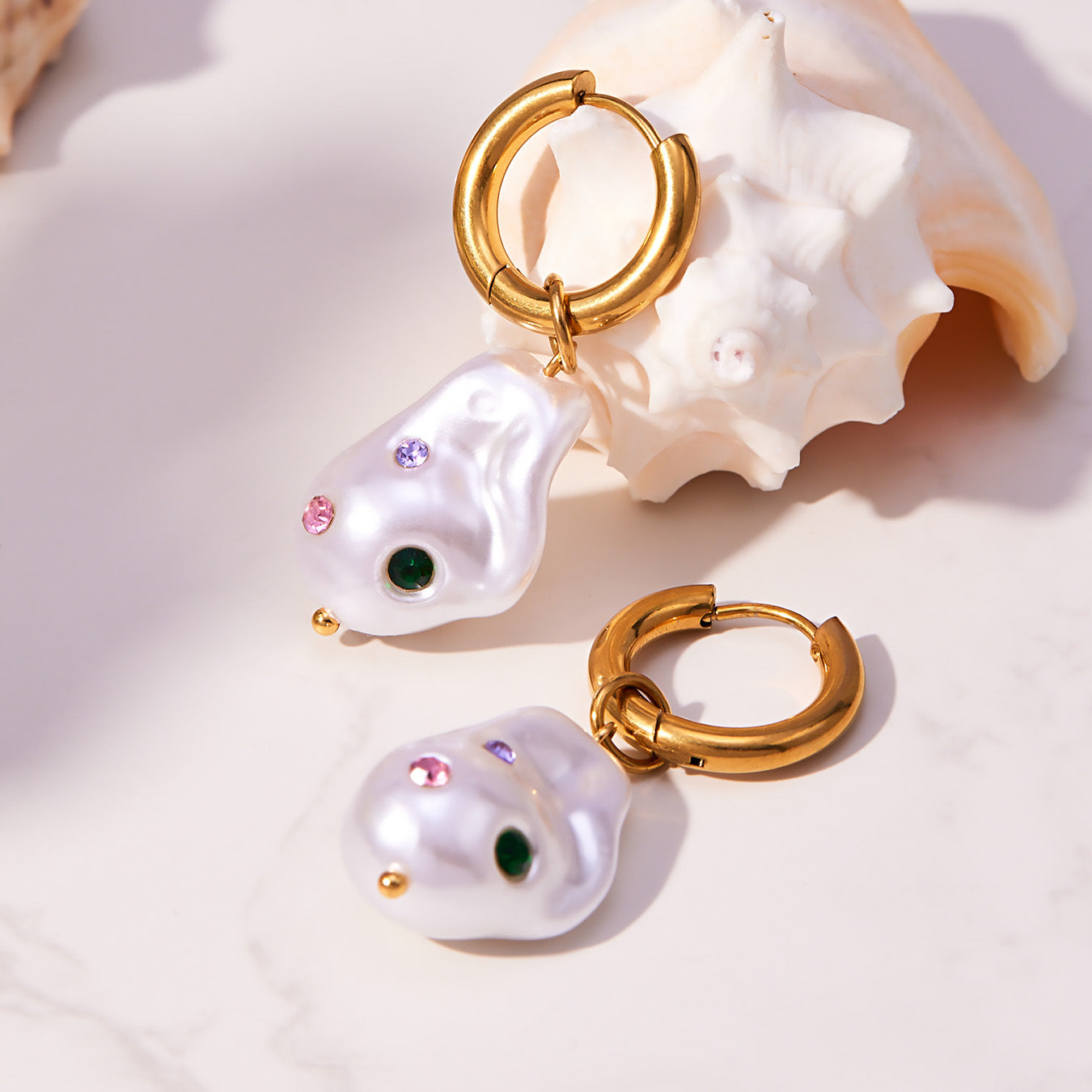 Close up detail of tarnish-free 316L stainless steel irregular baroque pearl earrings with embedded crystals.