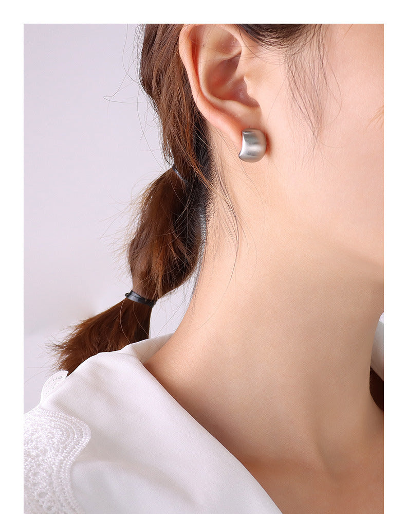 Close up of hypoallergenic jewelry featuring silver color 316L stainless steel C-shape hoops.