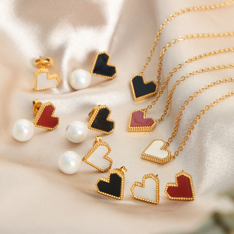 A collection of colorful heart necklaces and pearl earrings displayed together, highlighting various style options.