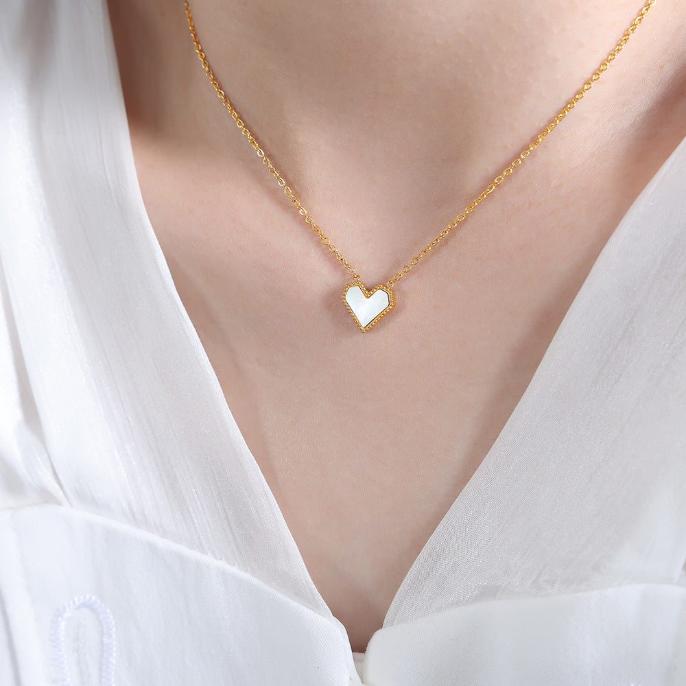 Gold French heart necklace featuring a tiny red inlay, showcasing its tarnish-resistant 18K PVD coating.