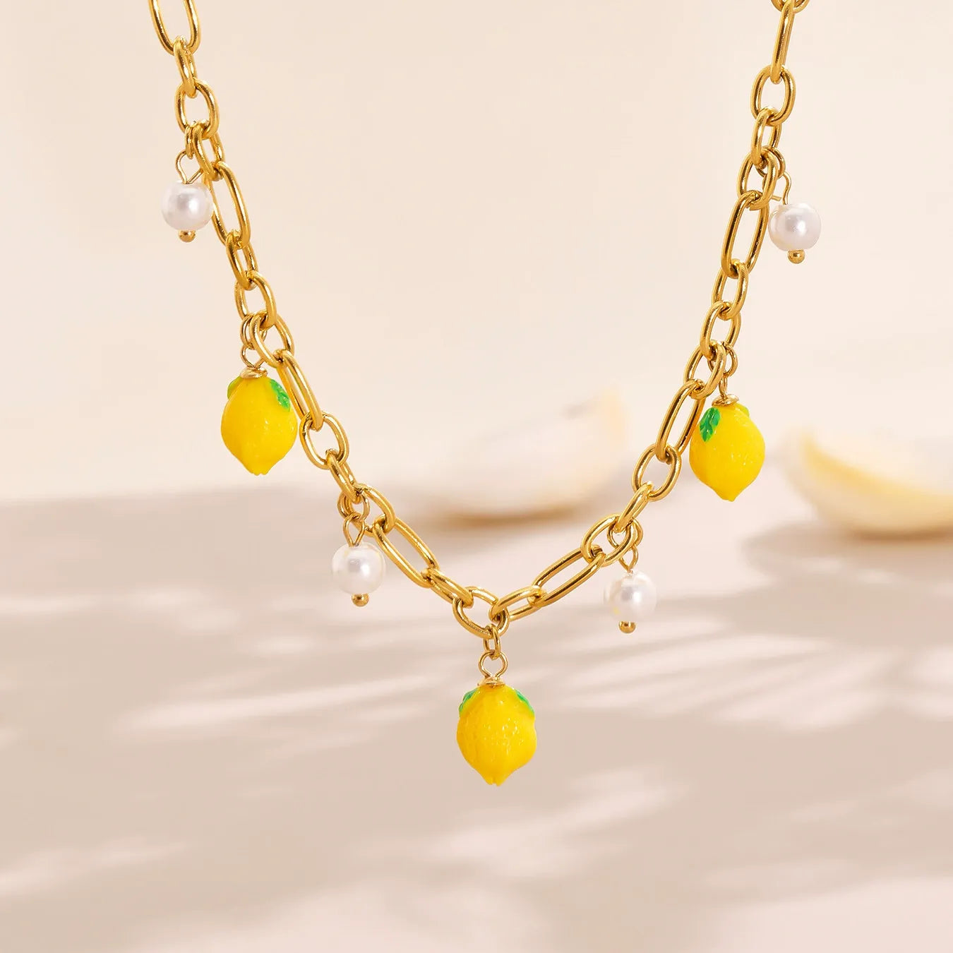 The 18K gold plated lemon and pearl necklace displayed in sunlight to highlight its tarnish-resistant and waterproof finish.