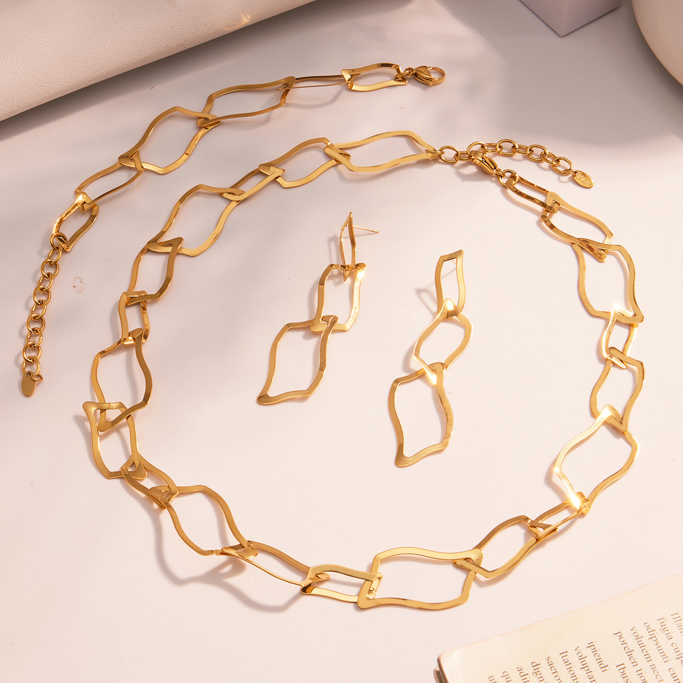 Detailed view of the waterproof 316L stainless steel geometric necklace and earrings set displayed on a soft aesthetic background.