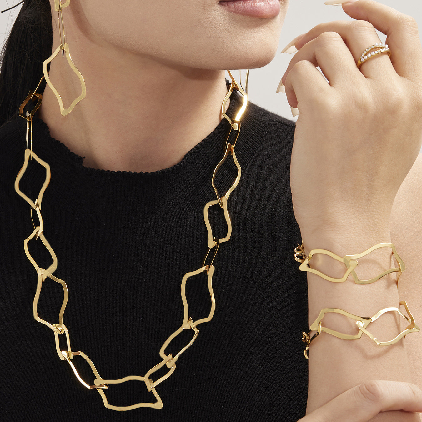 A model wearing a bold hypoallergenic irregular geometric link necklace and bracelet set, showcasing its contemporary look for daily style.