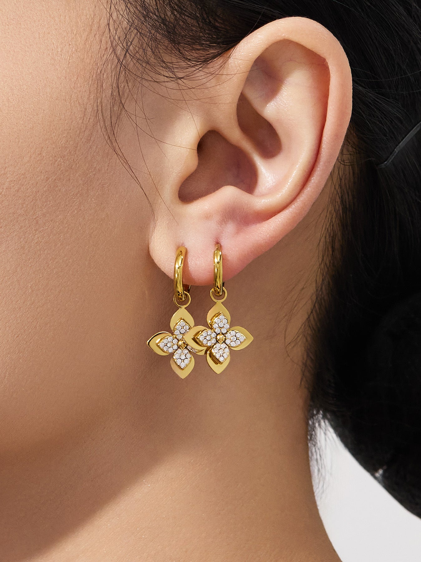Stylish four-petal flower drop earrings worn by a model, crafted from surgical-grade 316L stainless steel for sensitive ears.