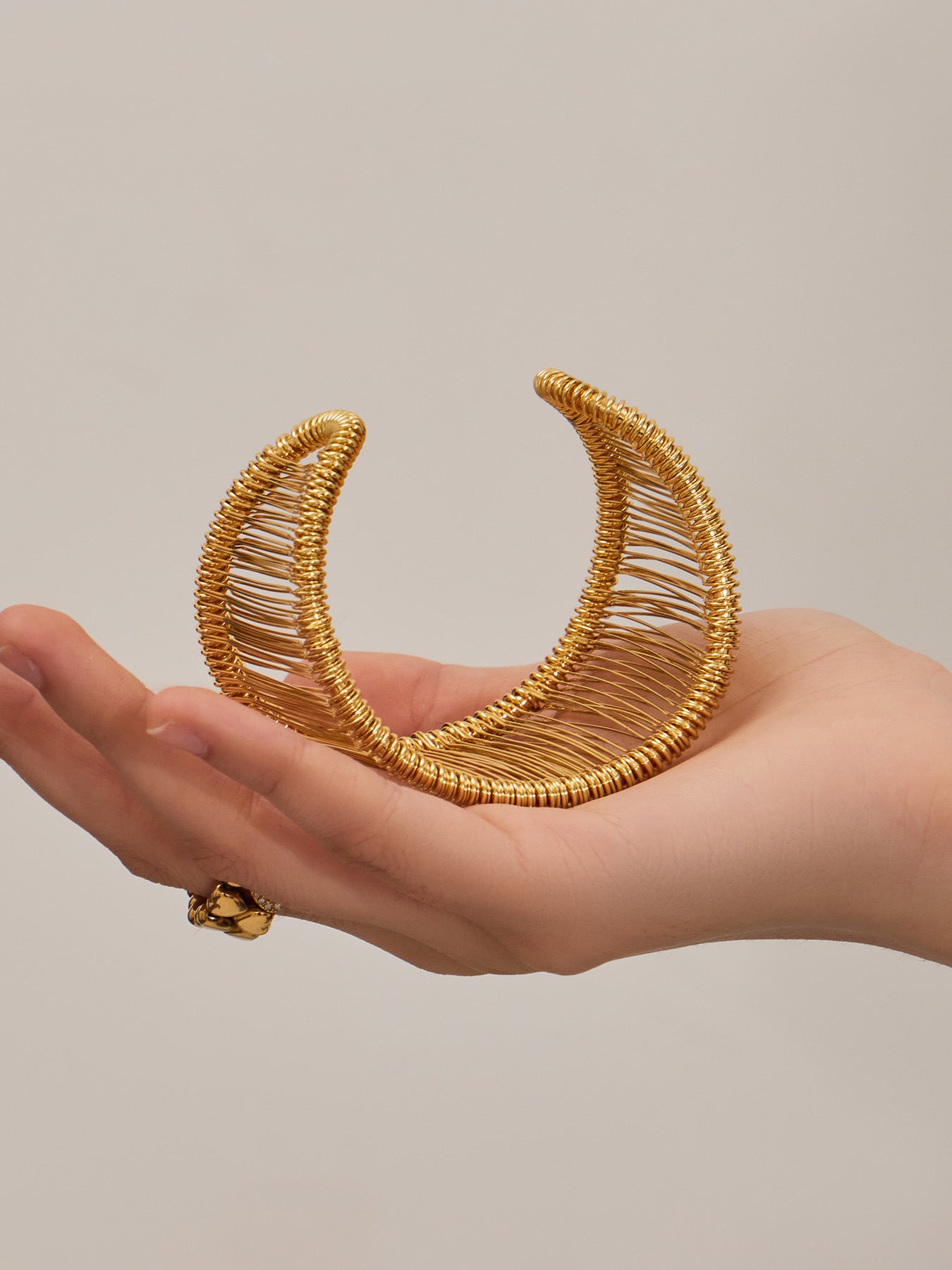 Gold wide wire cuff bracelet made of 316L stainless steel displayed on hand, lightweight open bangle for modern fashion styling