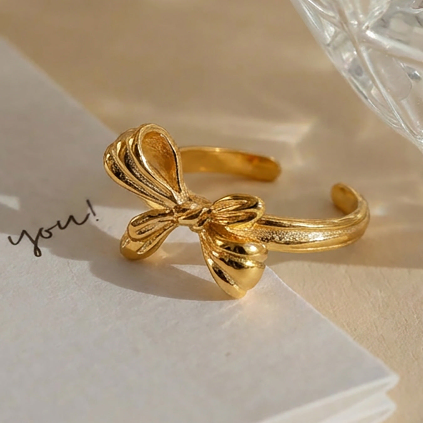 Minimalist stainless steel bow open ring with textured gold surface