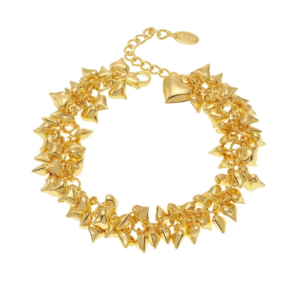 Gold chunky heart charm bracelet worn on wrist for boutique jewelry styling