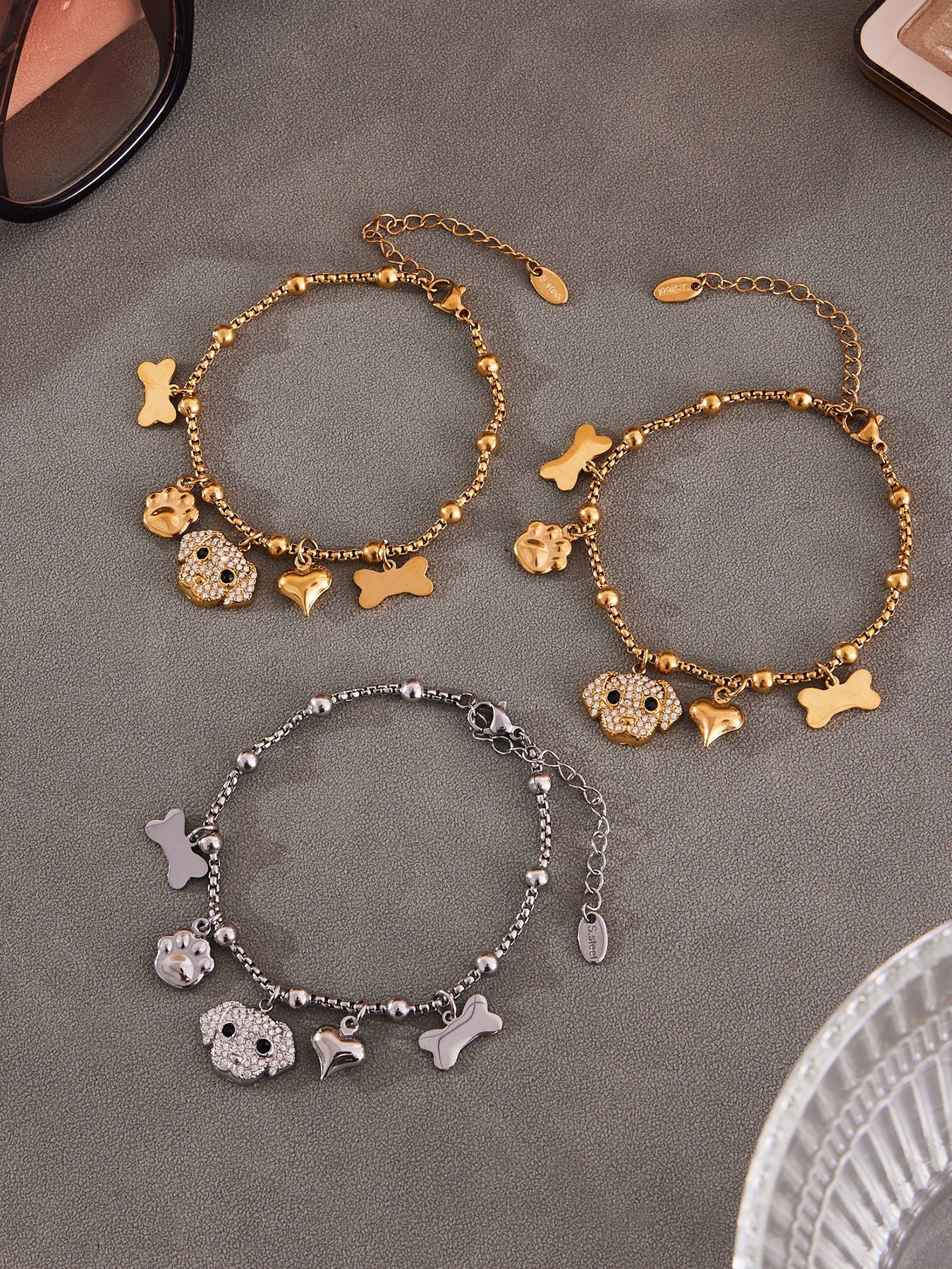 Flat lay of silver-tone 316L stainless steel dog bone jewelry set including necklace and bracelet with zircon.