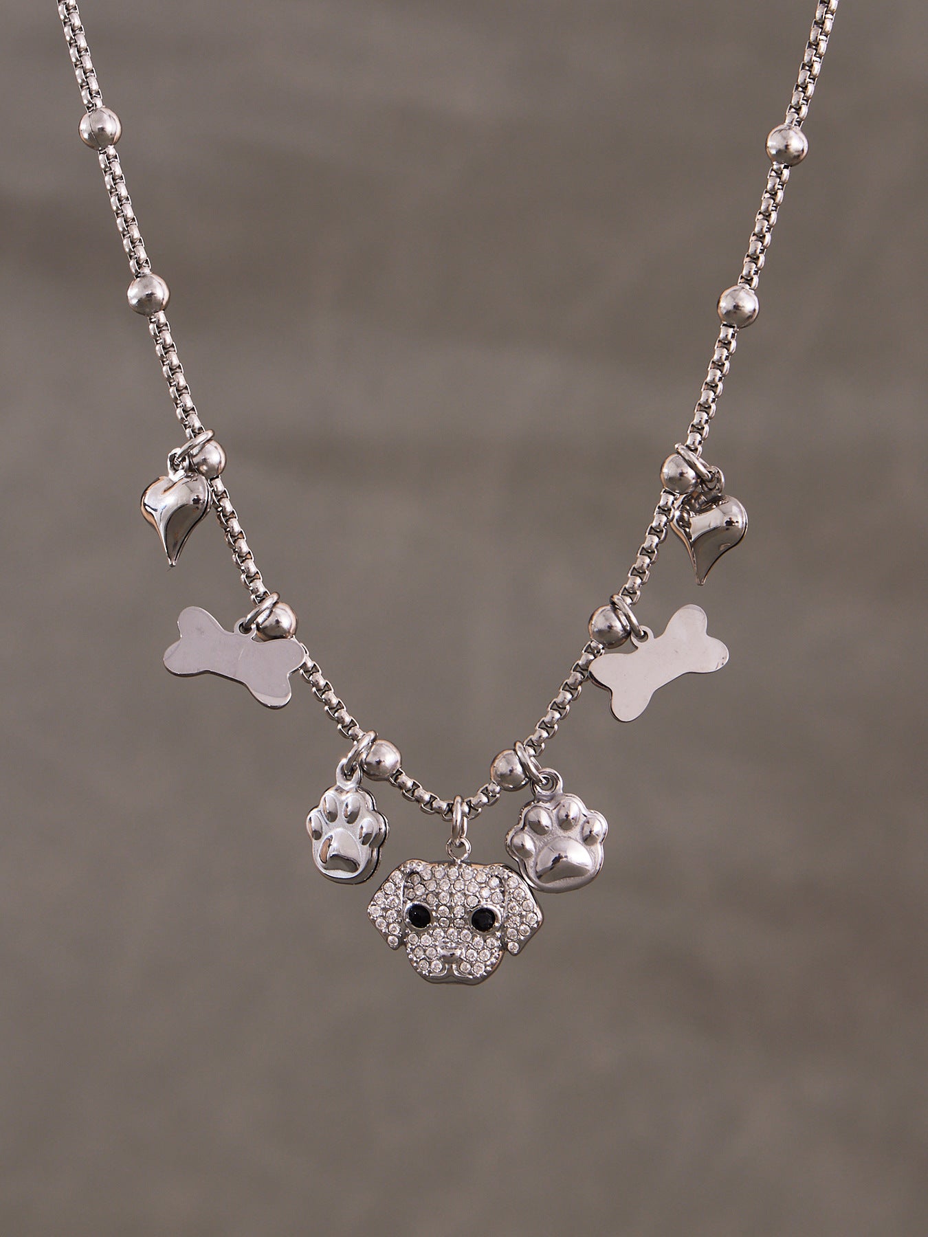 Silver-tone 316L stainless steel dog charm bracelet, hypoallergenic for sensitive skin, adjustable chain.