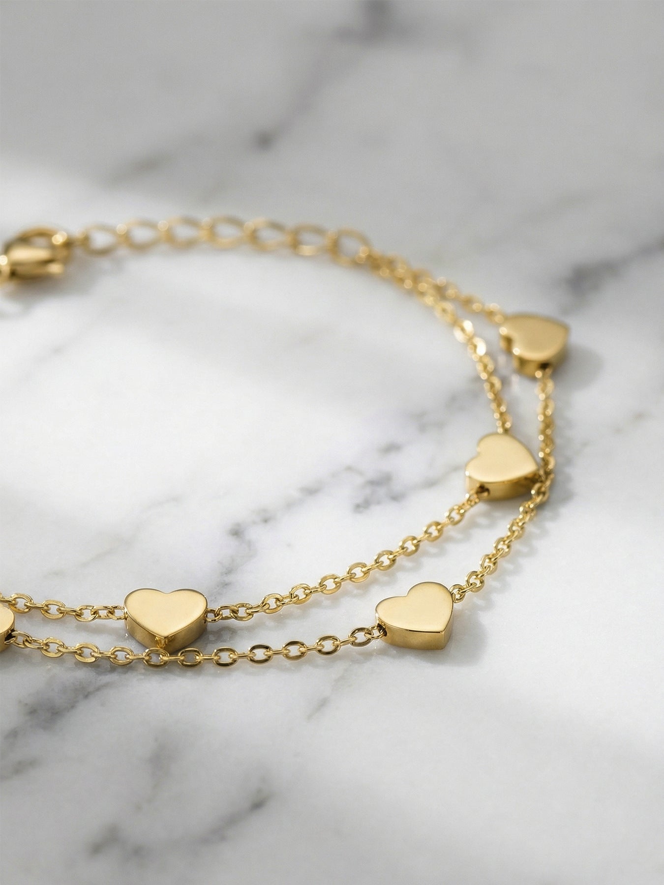 Hand wearing 316L stainless steel double layer heart chain bracelet, hypoallergenic for sensitive skin
