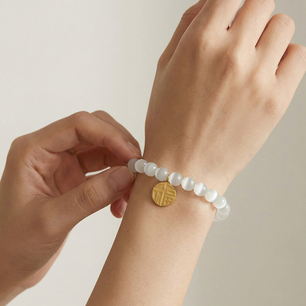Hand wearing 316L Stainless Steel cat's eye stone bead bracelet, lucky charm pendant detail