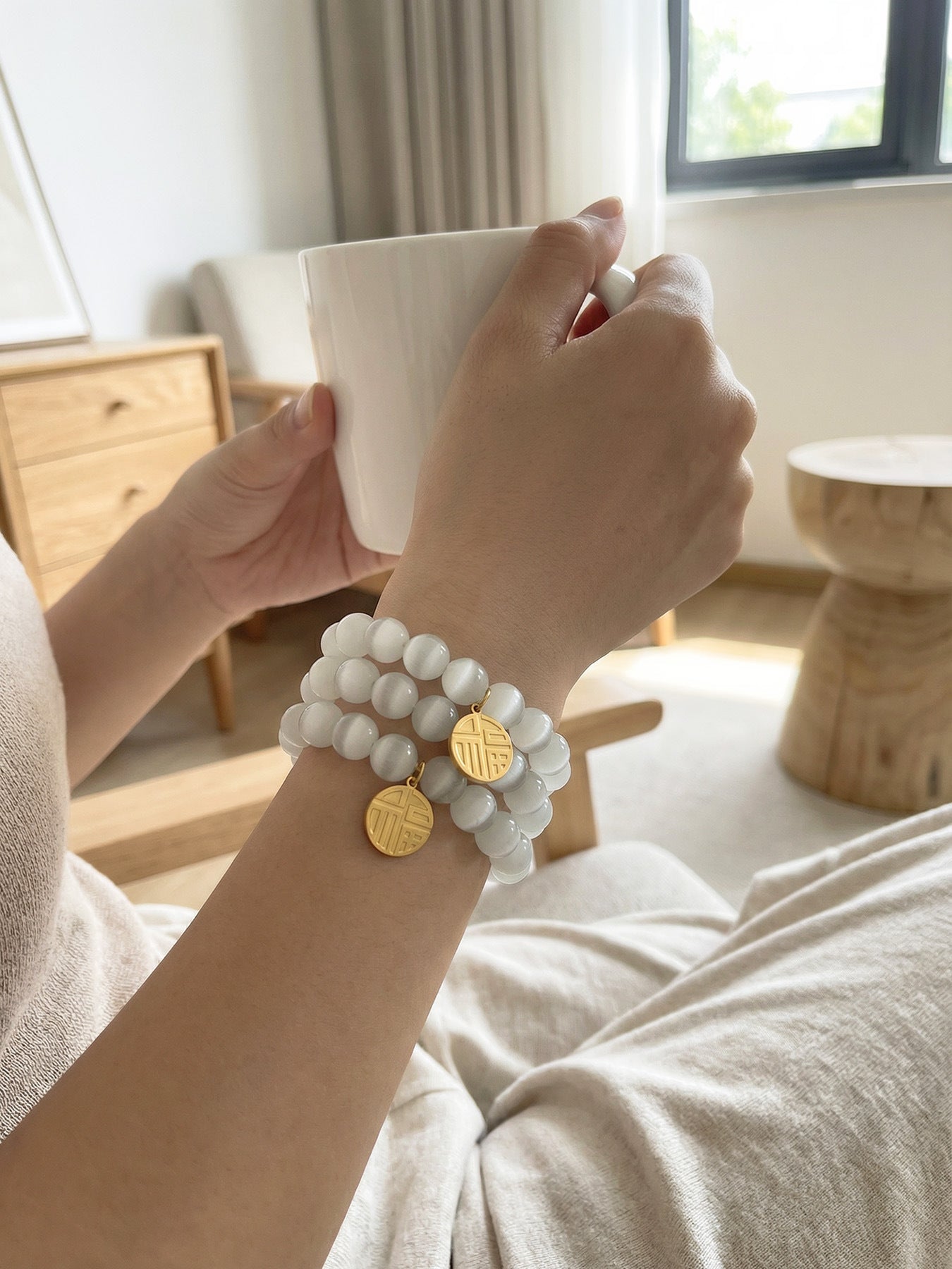 Close-up of cat's eye stone beads on 316L Stainless Steel bracelet, lucky charm pendant