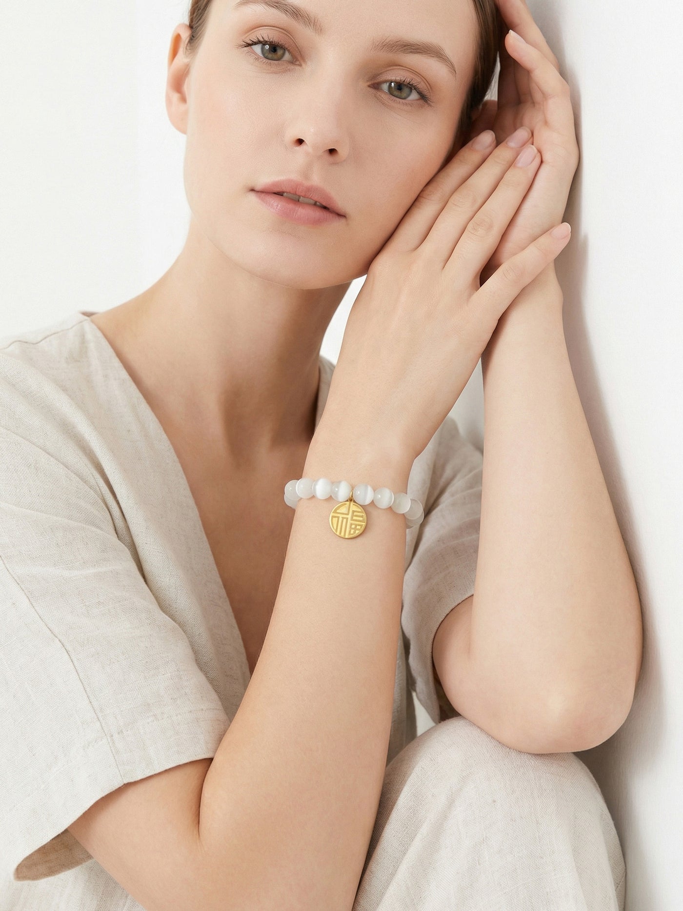 Model wearing 316L Stainless Steel cat's eye stone bead bracelet with lucky charm pendant, elegant style