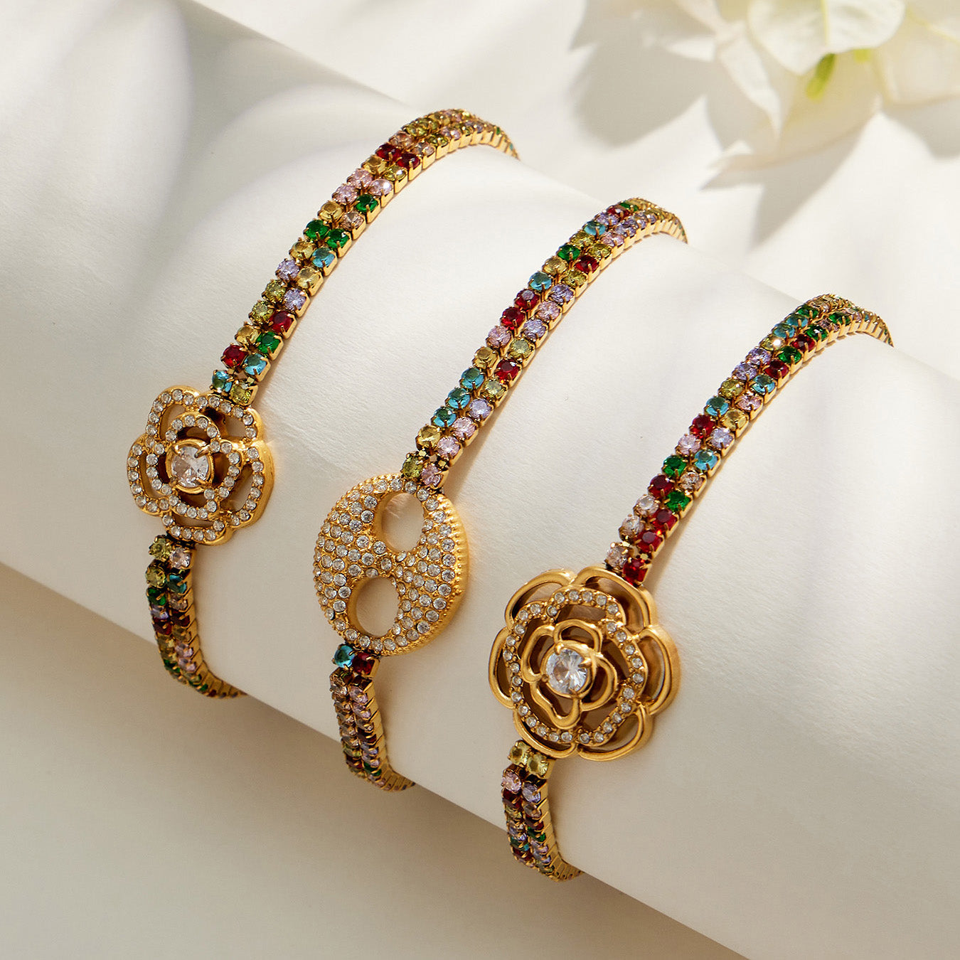 Three gold multicolor zircon bracelet designs with small flower, double-ring and large flower centers