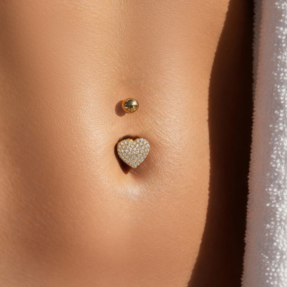 CZ belly button ring worn on model with gold heart design, fashionable body piercing jewelry