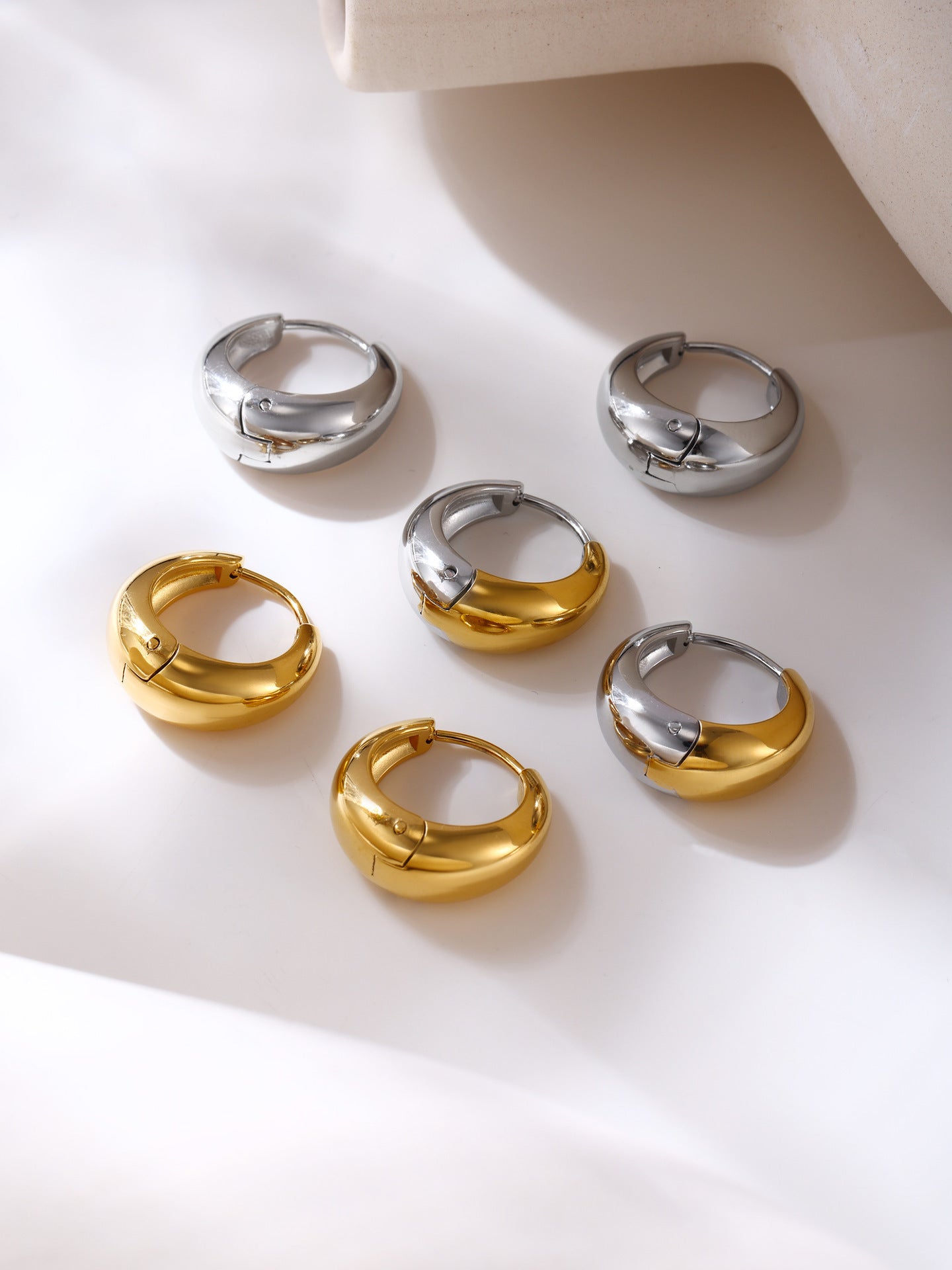316L stainless steel Mixed Metal Two-Tone Teardrop Huggie Hoop Earrings flat lay display for wholesale earrings buyers