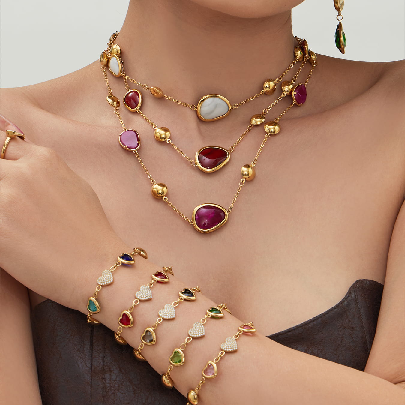 Model wearing 316L stainless steel glass stone necklace and bracelet set with colorful resin and heart zircon details