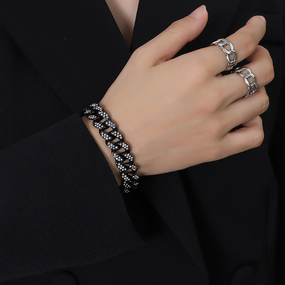 Model wearing a black Cuban link bracelet with clear cubic zirconia on the wrist