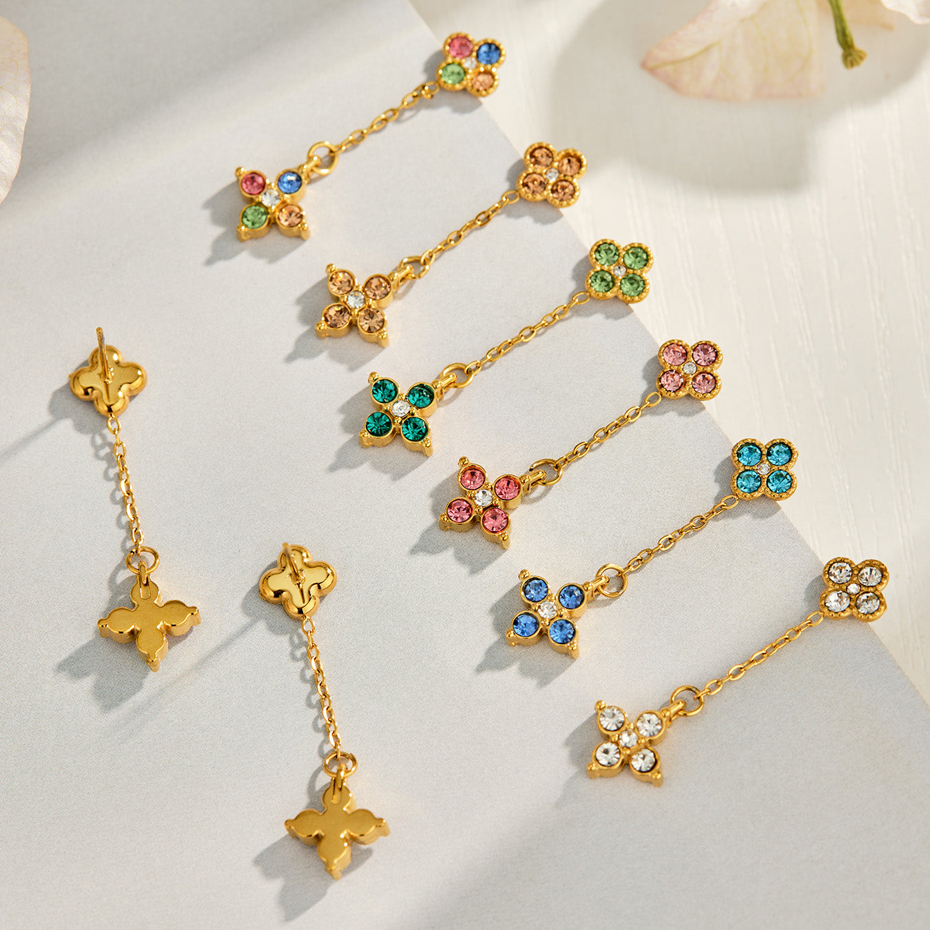 Colorful four-leaf clover cubic zirconia earrings arranged in a styled flat lay