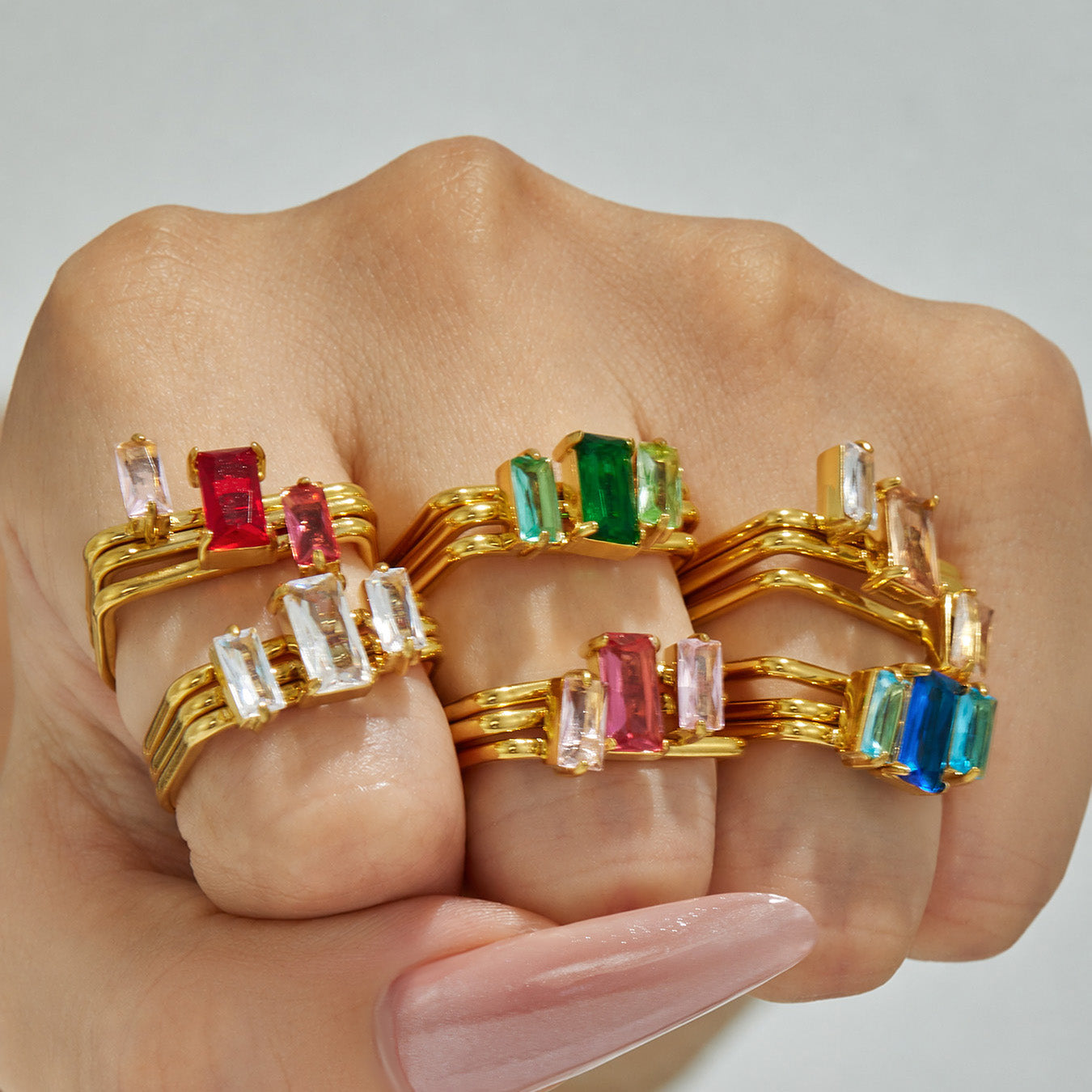 Model wearing multiple colorful cubic zirconia multi-band statement rings in 18K PVD gold