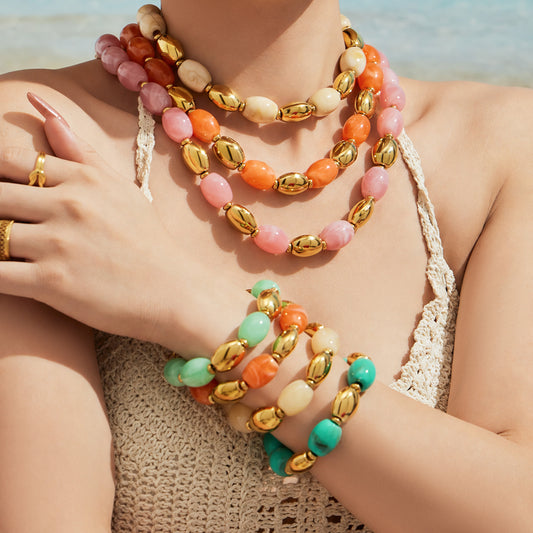 Model wearing layered colorful resin bead necklaces with matching stacked bracelets in a bold resort-inspired jewelry look