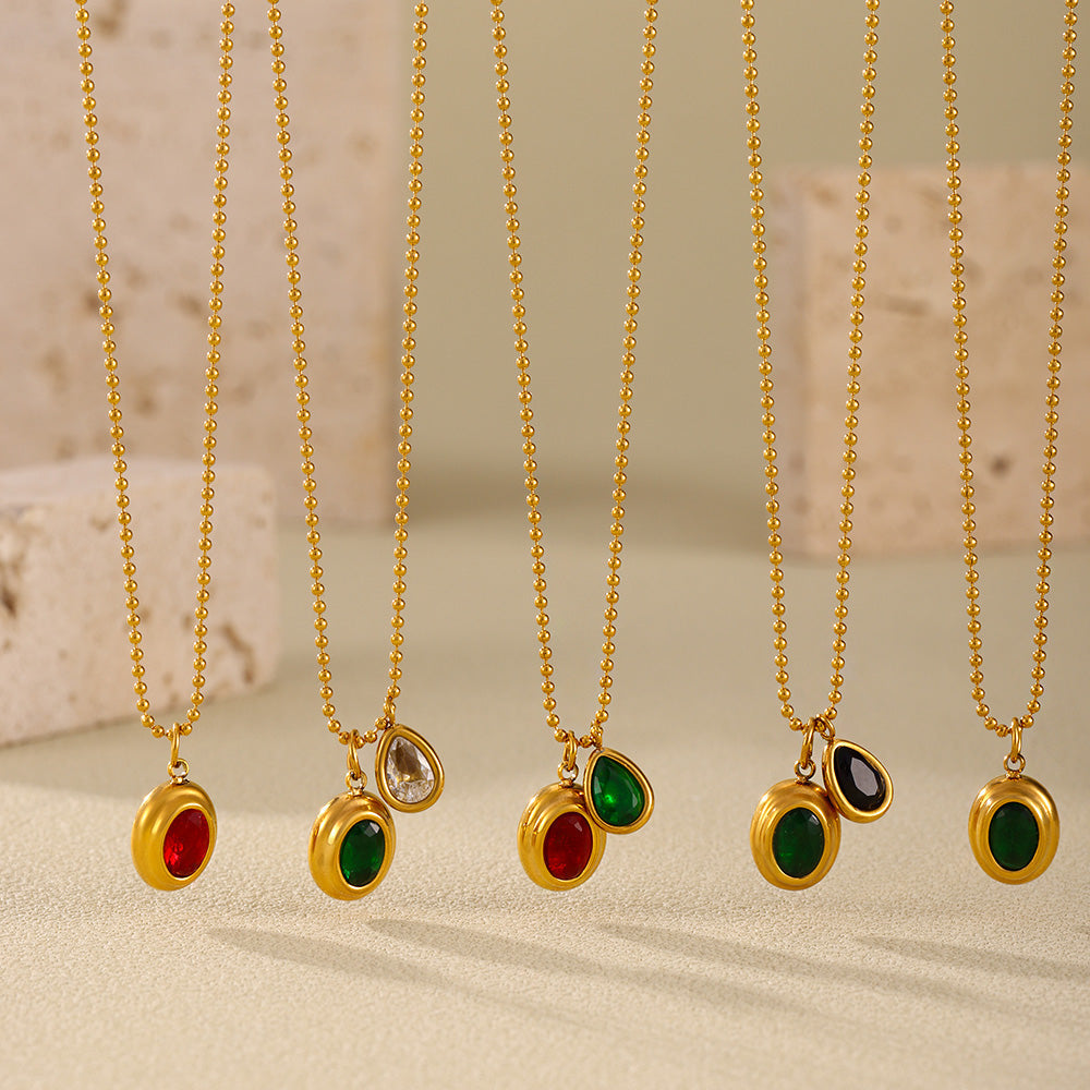 Assortment of gold ball chain necklaces with red, green and mixed zircon pendants