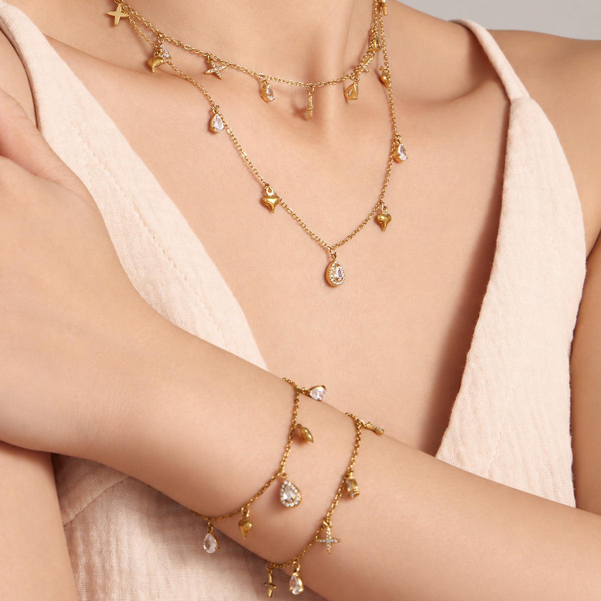 Gold-tone cross charm necklace and bracelet worn on model