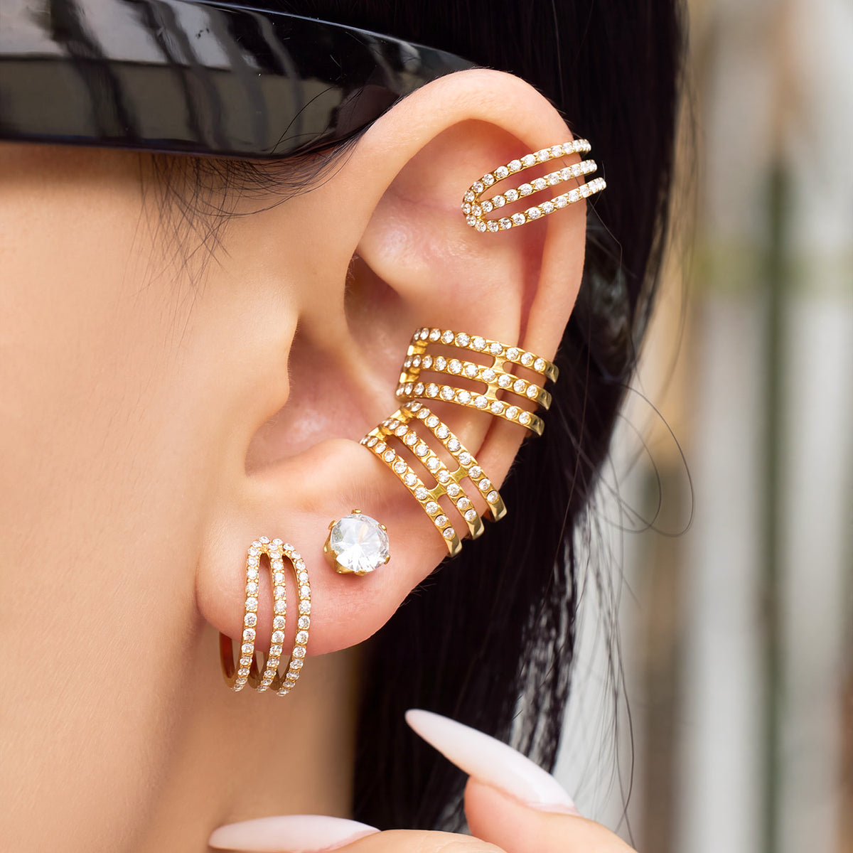 Close-up of gold zircon ear cuff worn on the cartilage with a layered multi-row silhouette