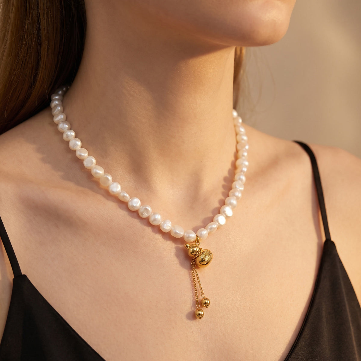 Freshwater pearl necklace with gold gourd charm worn on model