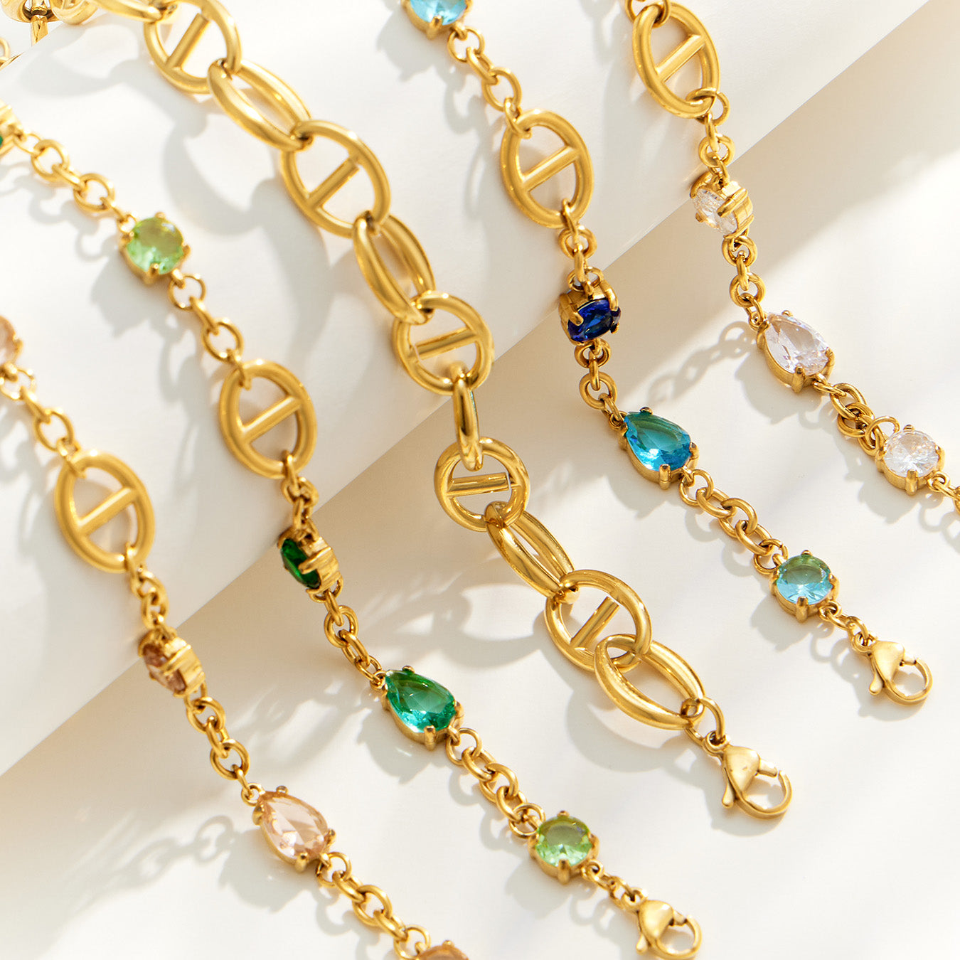 Oval link bracelet assortment showing gold chain construction and colorful zircon details