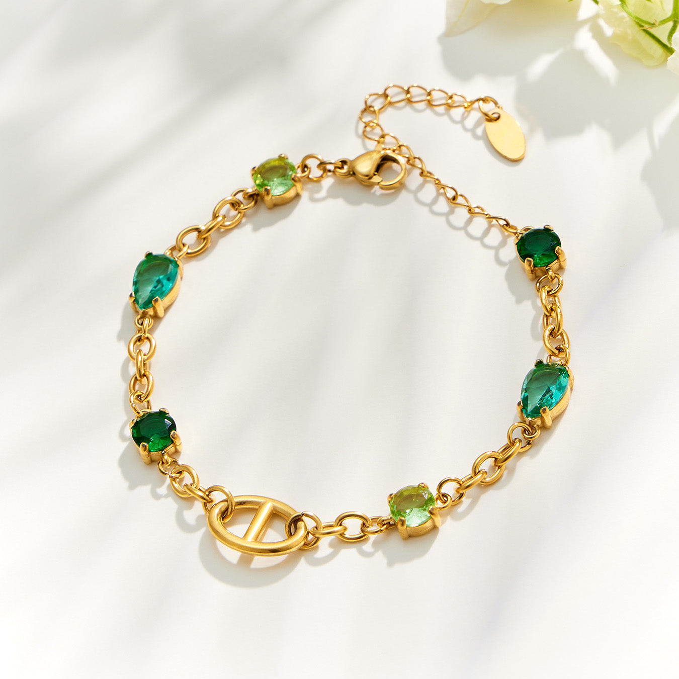 Gold oval link bracelet with green zircon stones and adjustable extension chain