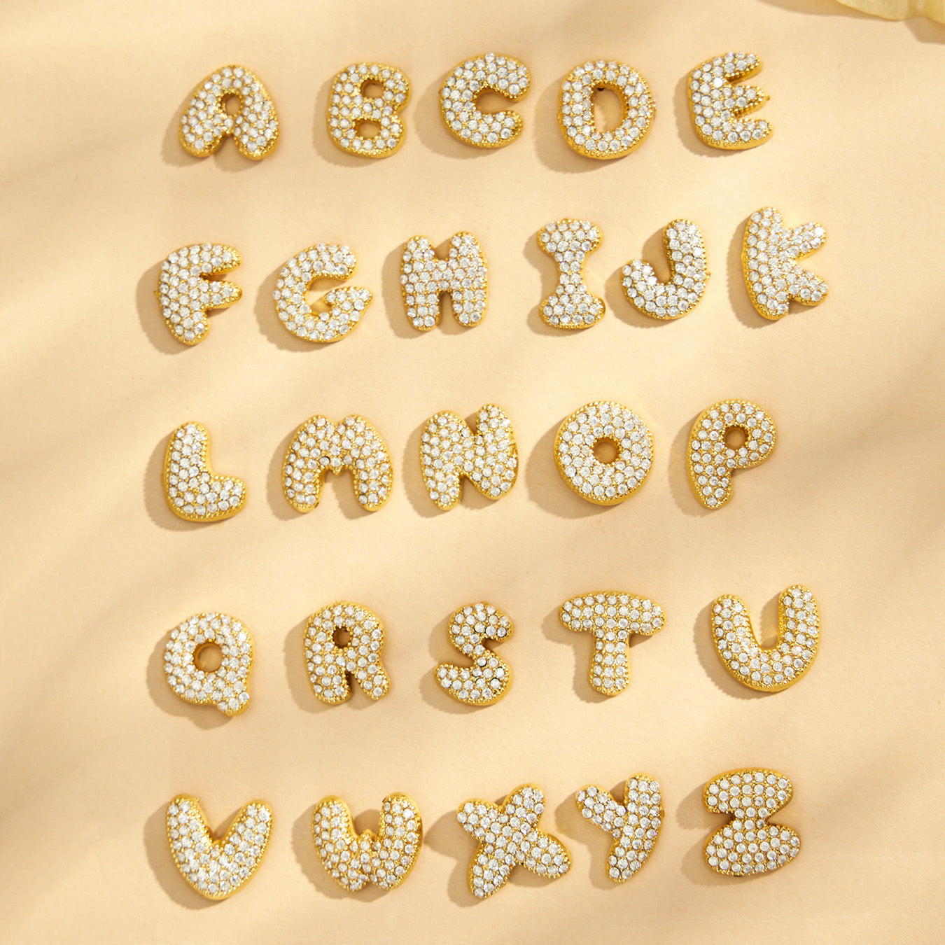Gold alphabet stud earrings arranged to show multiple letter options