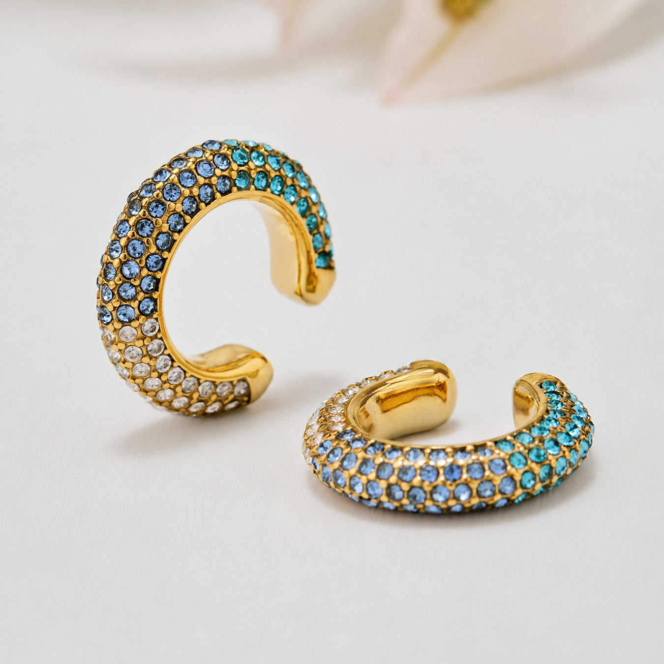 Gold C-shaped ear cuff with blue cubic zirconia pavé detail