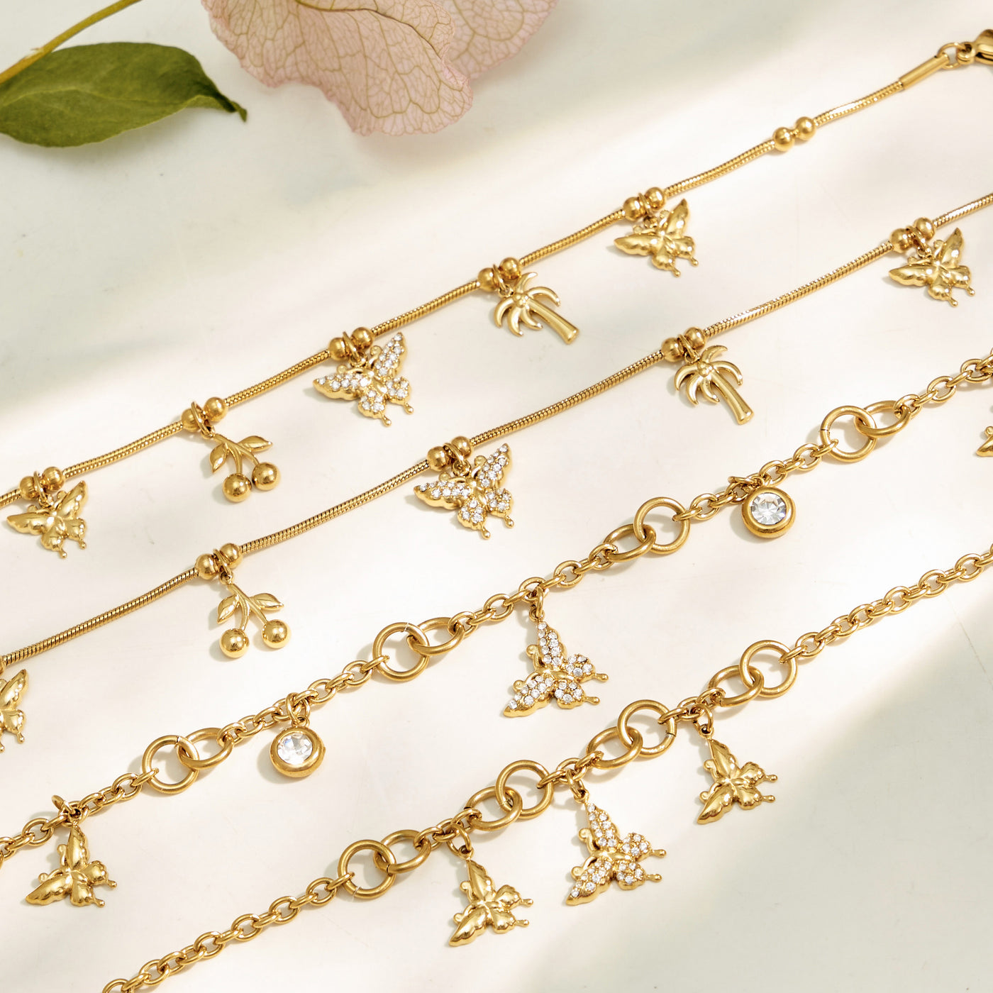 Close-up of gold butterfly zircon charms arranged along delicate link chains