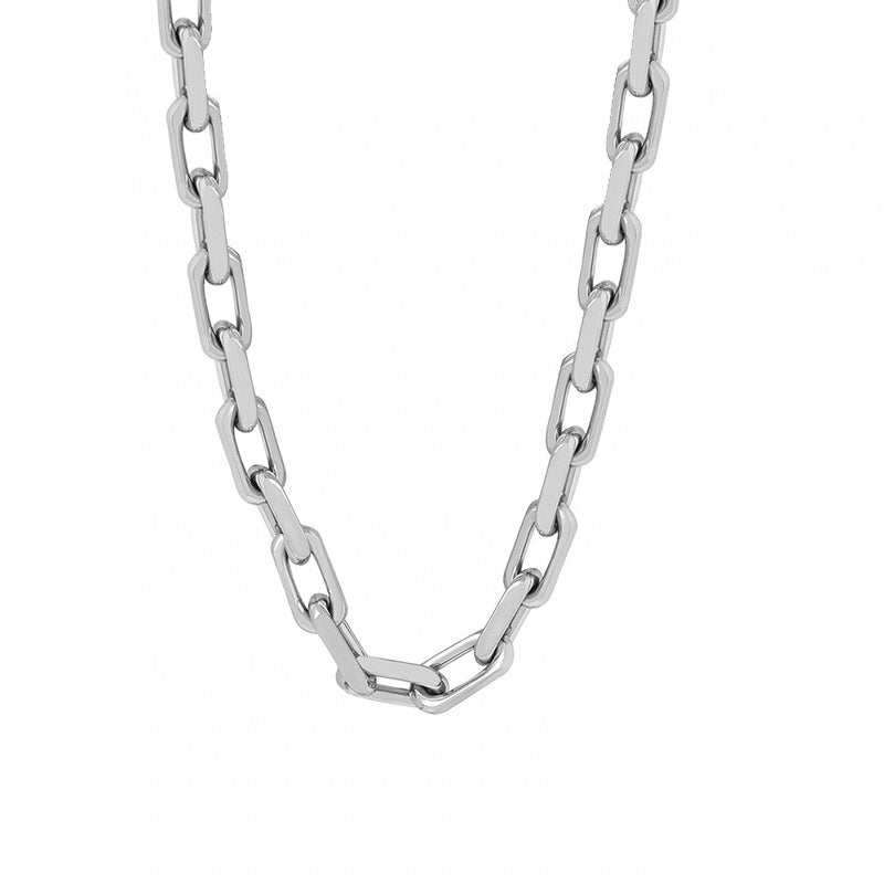 Gold stainless steel chain necklace detail draped over a wooden prop