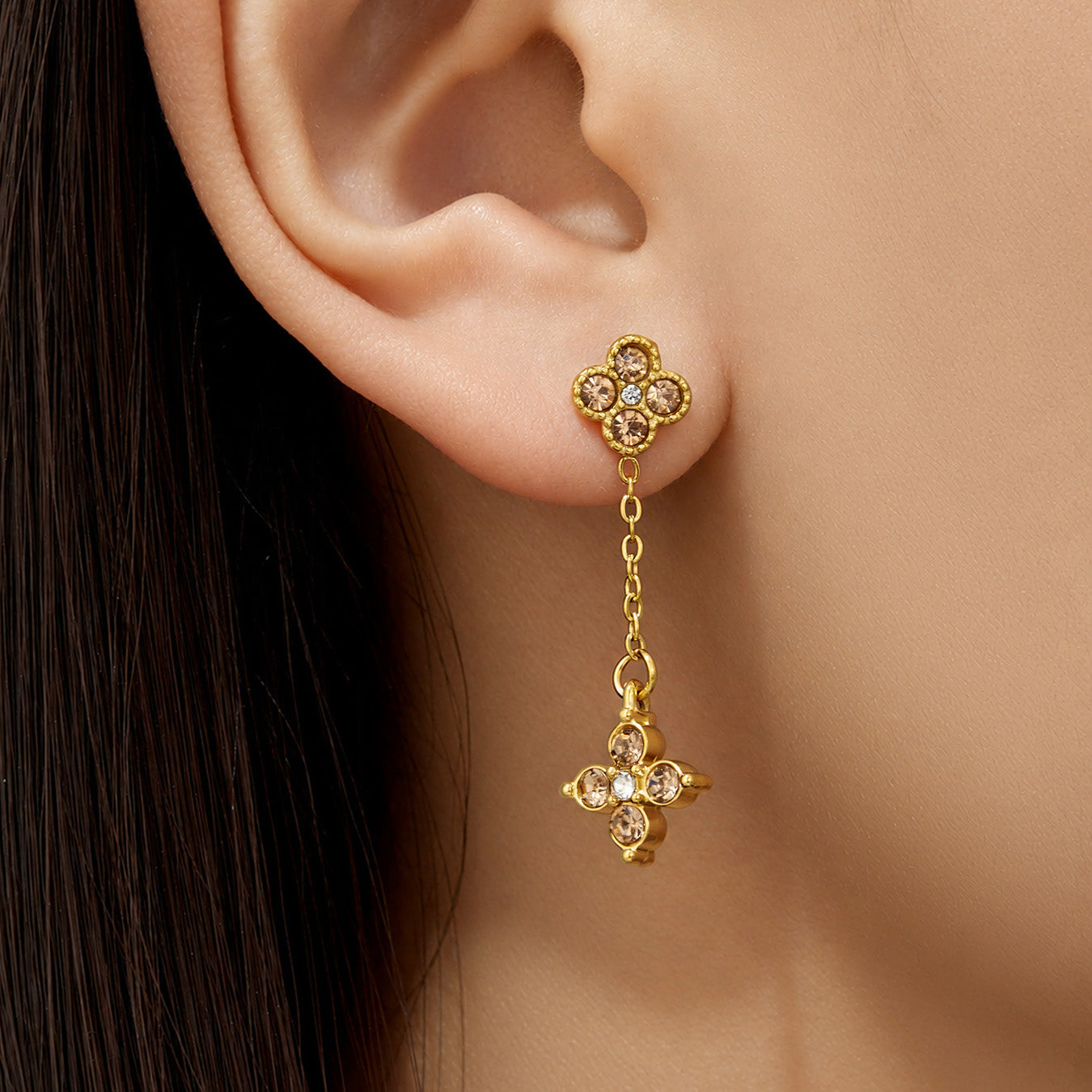 Model wearing gold four-leaf clover cubic zirconia drop earrings