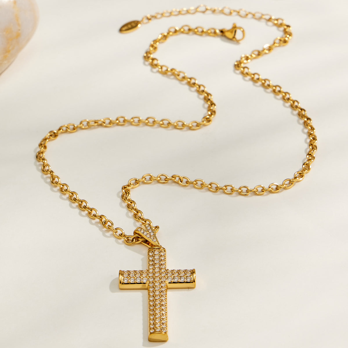 Gold cross chain necklace flat lay