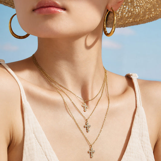 Model in a straw hat wearing a delicate gold cross zircon pendant necklace
