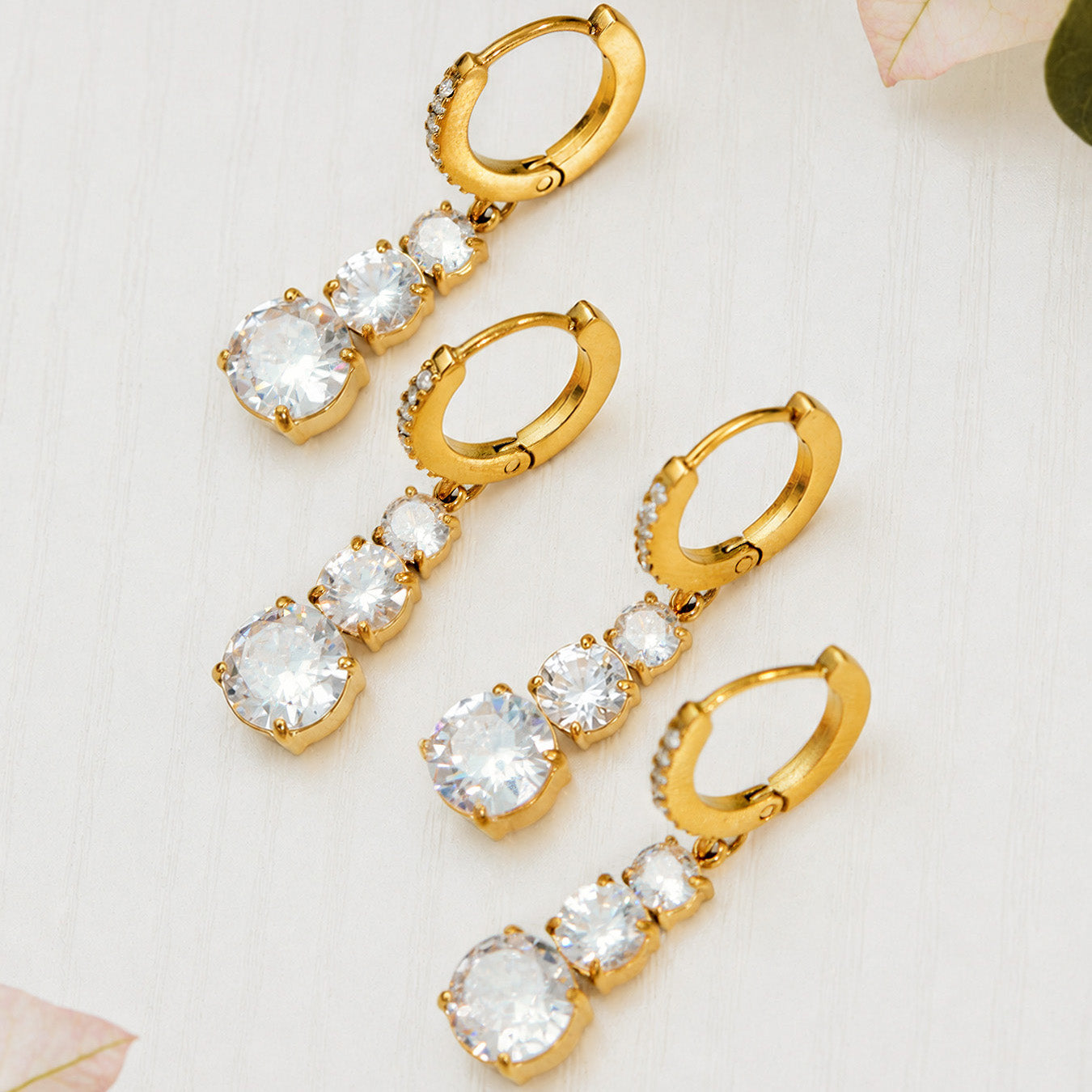 Collection of gold cubic zirconia earrings in hoop and droplet styles