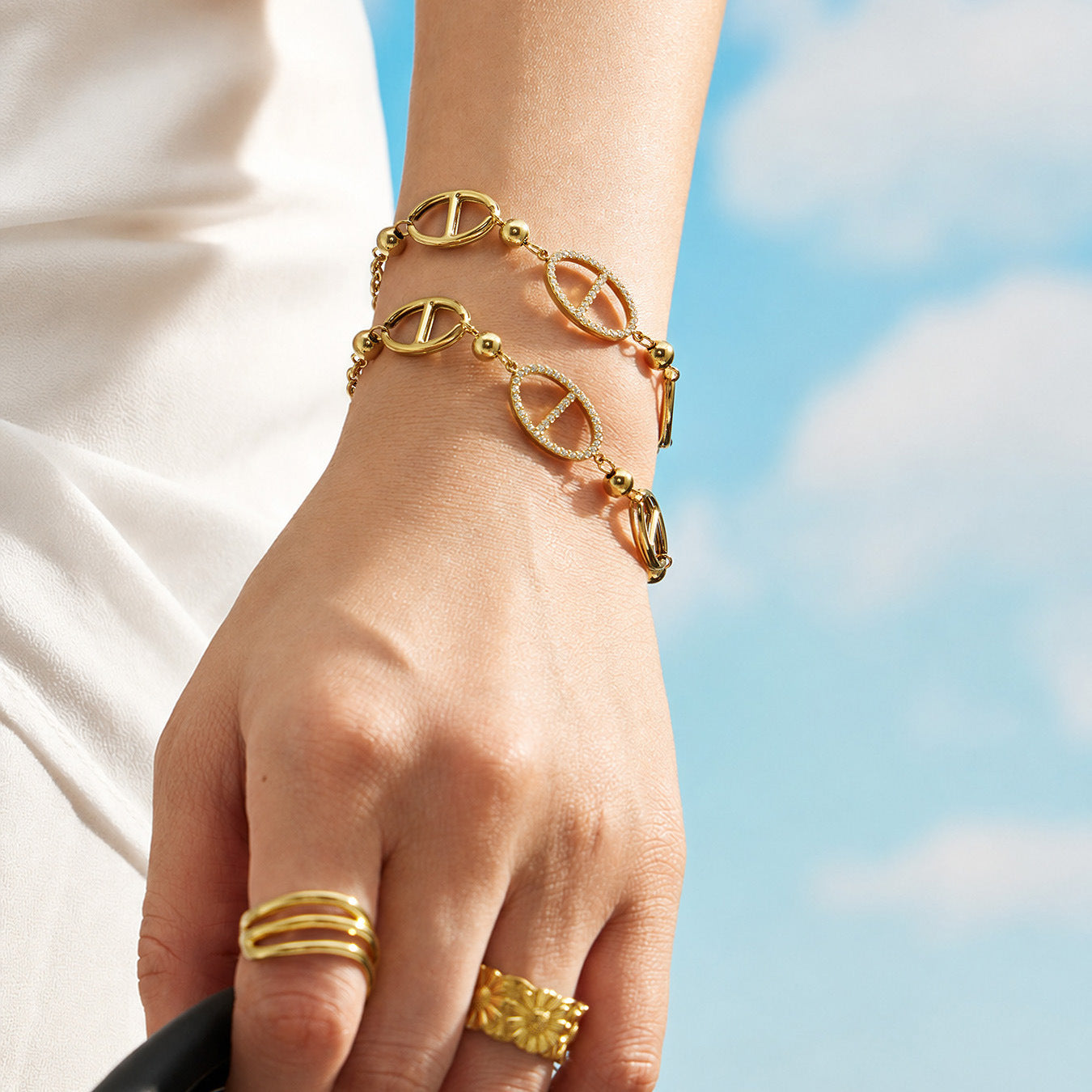 Close up of gold D-shaped zircon bracelet worn on wrist with 316L stainless steel geometric charm details