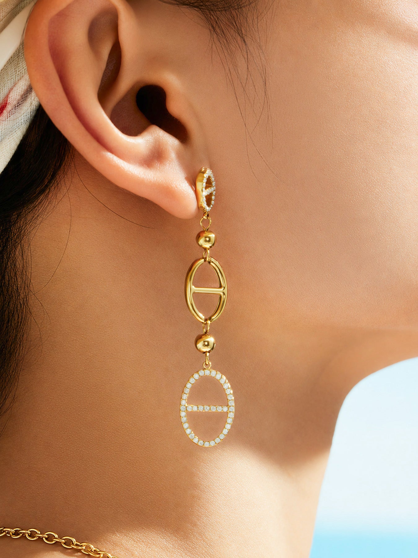 Close up of gold D-shaped zircon bracelet worn on wrist with 316L stainless steel geometric charm details