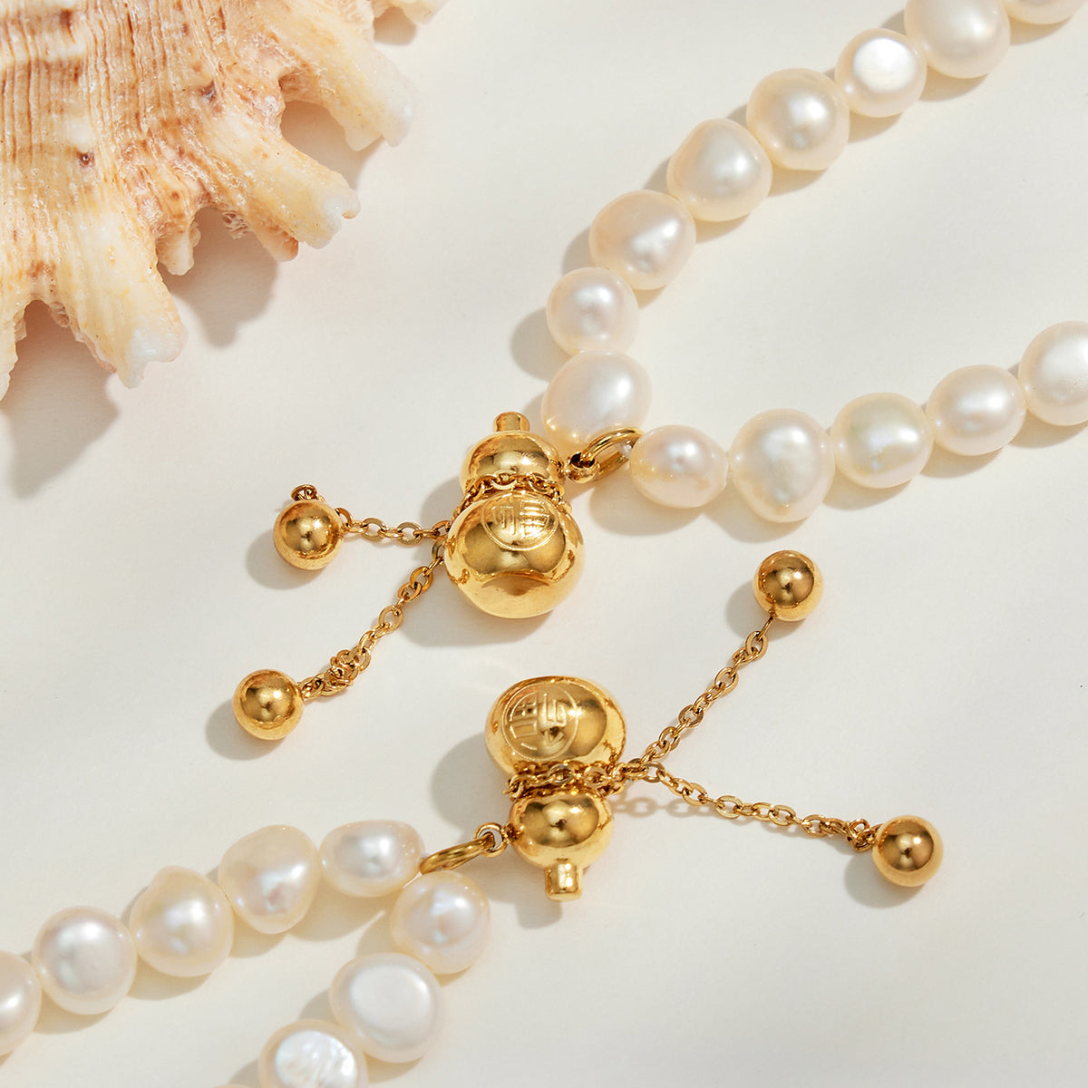 Gold gourd charm and freshwater pearl necklace detail