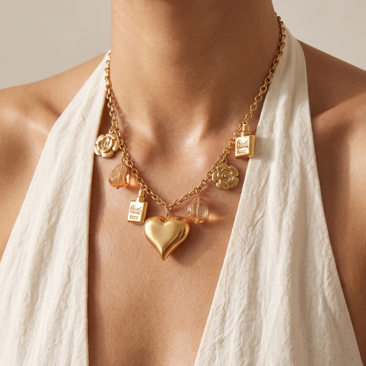 Gold heart charm necklace with resin and flower details worn on model