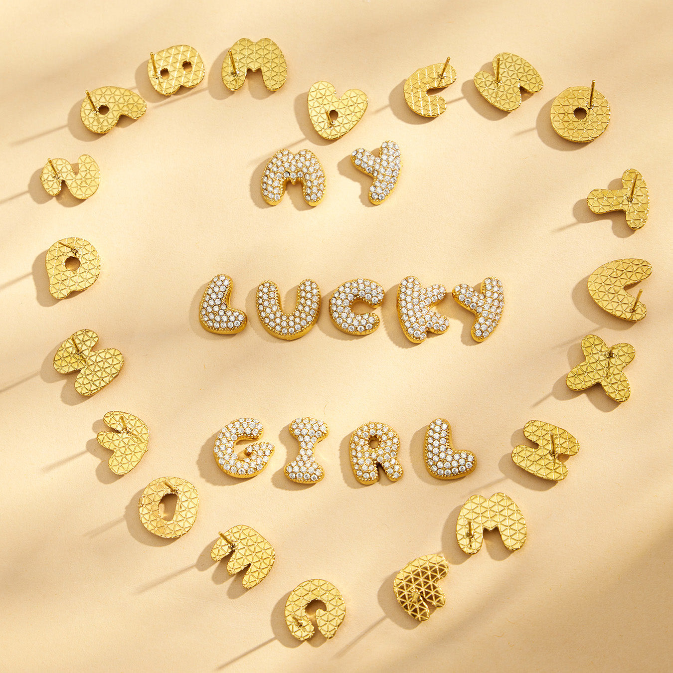 Gold initial letter stud earrings arranged in a heart around the word Lucky