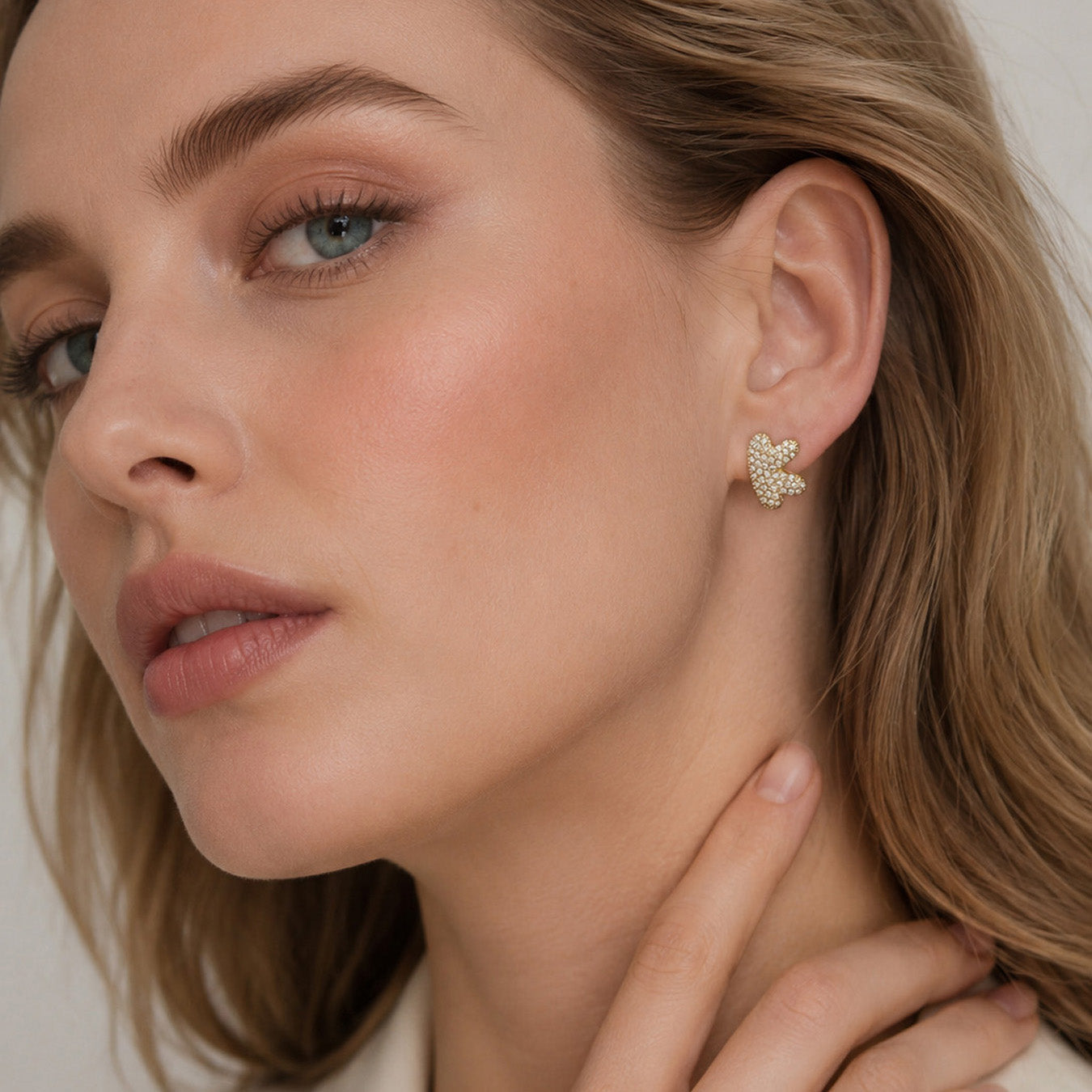 Close-up of model wearing gold initial letter stud earrings