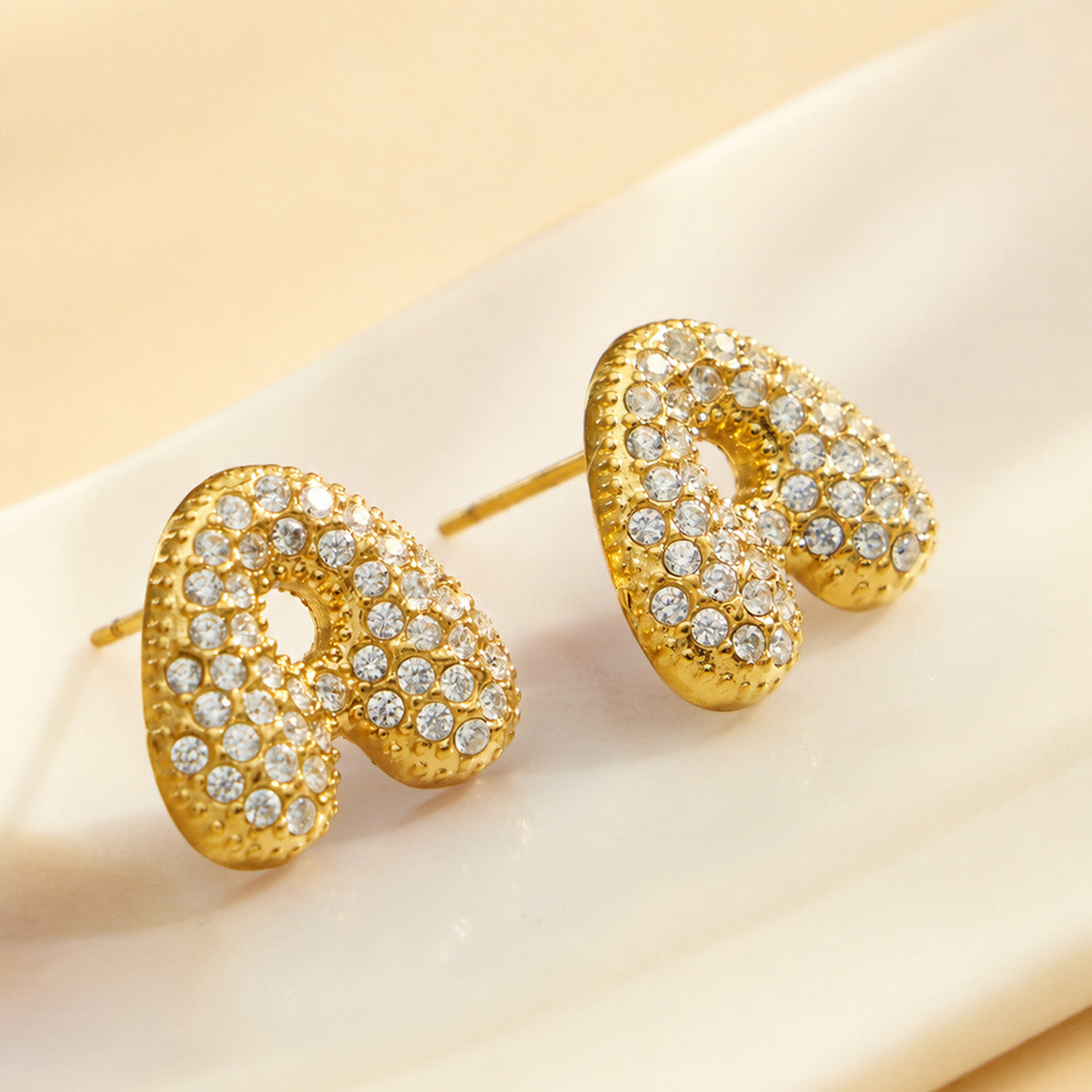 Close-up of pavé gold letter A initial stud earrings