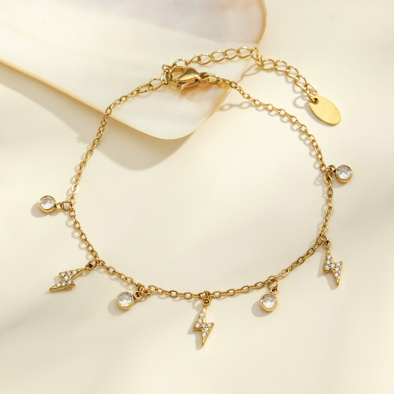 Gold stainless steel charm bracelet with zircon lightning bolts and round crystal pendants