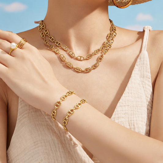 Model wearing a gold mariner link necklace with a coordinating chain link bracelet